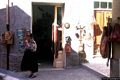Dorgali: botteghe e negozi di artigianato: donna dorgalese fuori da una bottega di artigianato