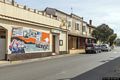 Lotzorai-Sulla facciata della Pro Loco il murale che rappresenta figure maschili e femminili con vedute di chiese e paesaggi