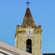 Orgosolo-Chiesa parocchiale di San Paolo Apostolo: l'orologio che guarda a ovest con un quadrante a cifre romane che segna sempre le 12 e 03