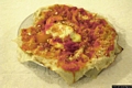 Porto Torres-Il ristorante Li Lioni: <em>Pane frattau</em>, piatto nuorese ottenuto con <em>Panecarasau</em> ammorbidito nel brodo e condito con pomodoro, formaggio e uovo in camicia
