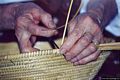 San Vero Milis-Lavorazione dei cestini di giunco: la signora Maria, tramite un grosso ago, avvolge l’anima in giunco della corbula con S’anedda o zinniga