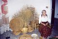 San Vero Milis-Lavorazione dei cestini di giunco: vari canestri, fuscelle, una bottiglia rivestita, una corbula, e sullo sfondo dei soli, oggetti ornamentali da appendere alle pareti assai richiesti dai turisti
